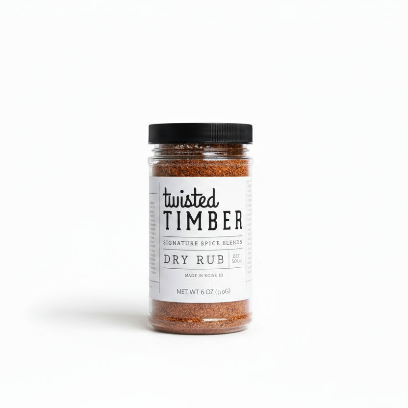 Three jars of Twisted Timber dry rub on a countertop with a blurred basket of wings in the background.